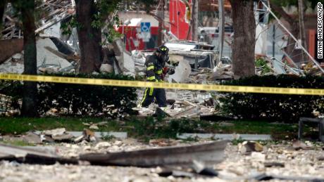 A firefighter walks through the remains of a building after an explosion on Saturday, July 6, 2019, in Plantation, Fla. 