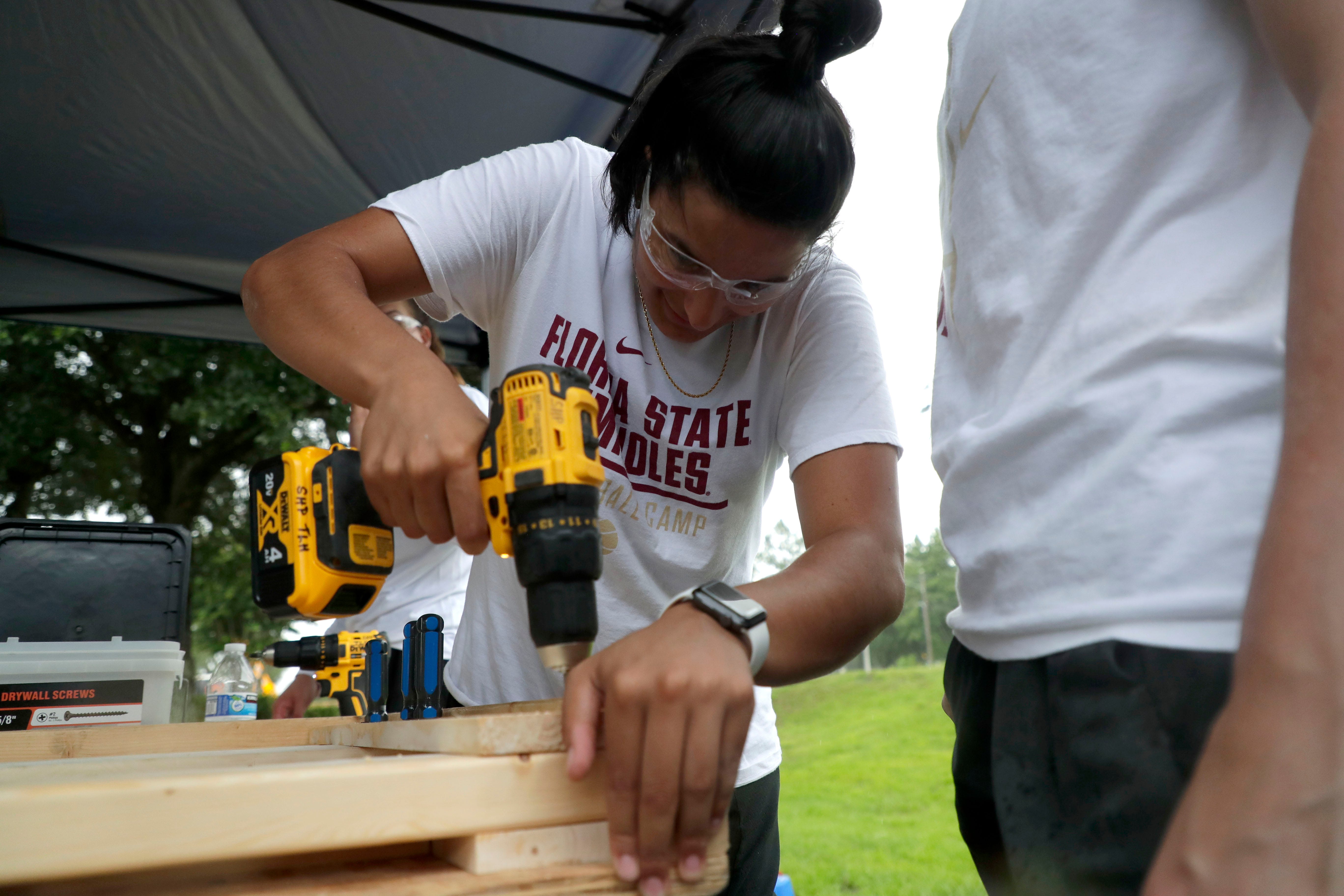 Izabela Nicoletti, a member of the Florida State women's basketball team, uses a drill to put together a headboard for a bunkbed for children in the Big Bend. FSU women's basketball teamed up with Texas Roadhouse and other volunteers to complete the project Tuesday, July 23, 2019. 