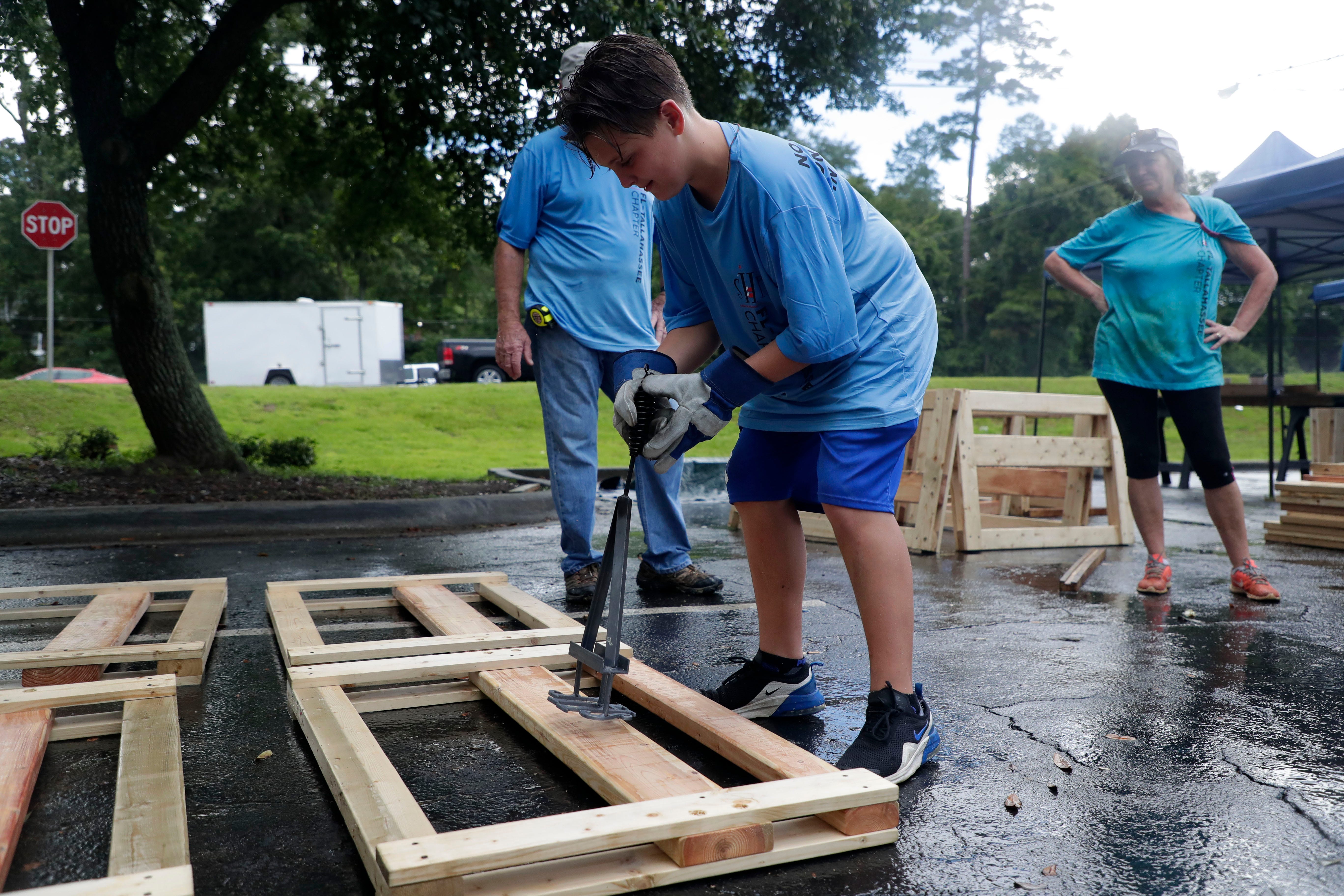 Mason Stafford, 11, brands the Sleep in Heavenly Peace logo to a headboard. FSU women's basketball teamed up with Texas Roadhouse and other volunteers to build bunkbeds for children in the Big Bend Tuesday, July 23, 2019.