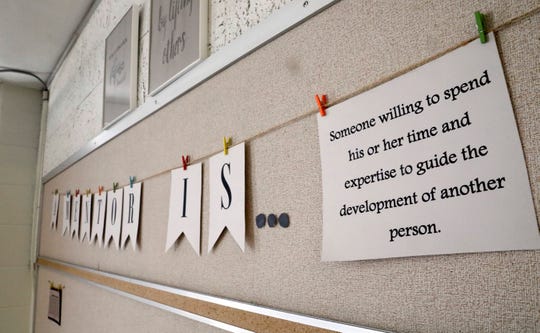 A sign hanging in a group space used for mentorship gives a definition of a mentor. The space is used by the Fairfield County Juvenile Court to do group mentoring programs with children involved with the court.