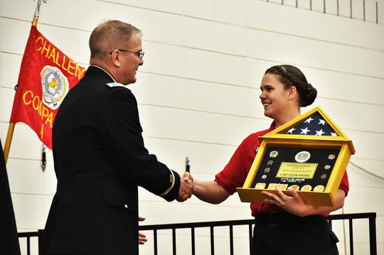 Col. Tim Covington, Wisconsin Army National Guard chief of staff, presents Wisconsin National Guard Challenge Academy Cadet Taylor Nowinski with the distinguished honor graduate award during a June 22 ceremony at Necedah High School. Challenge Academy is a voluntary program for teens at risk of not graduating high school. A military-style environment, guided by state-certified educators and counselors, develops academic skills, character, confidence and personal discipline. Class 42 had 101 cadets graduate from the 22-week residential phase of the program.