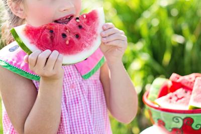 Girl eating watermelon during summer