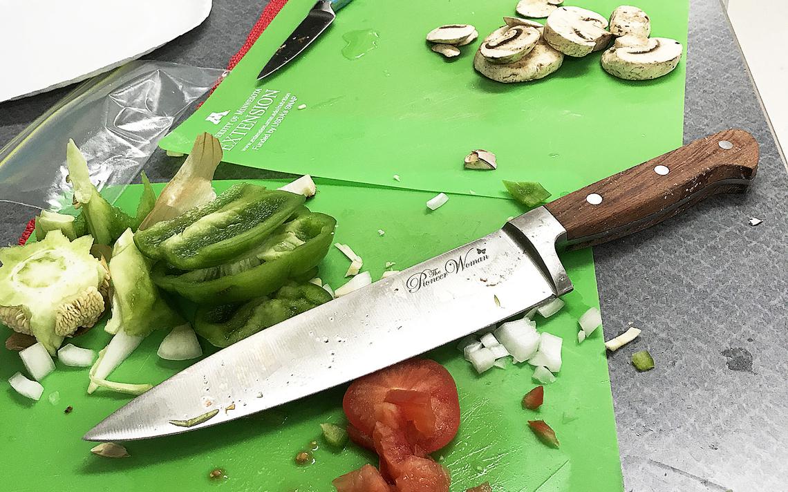 Students cut vegetables of their choice and topped two pizzas for each group in a recent Cooking Matters class. Jamie Lund/Pine Journal