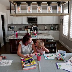 Amy Watts does educational worksheets with her daughters, Nora, 6, Eve, 4, and Reese, 9, to prepare for the coming school year at their home in Lehi, Utah, on Saturday, Aug. 17, 2019.