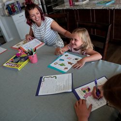 Amy Watts does educational worksheets with her daughters, Nora, 6, Eve, 4, and Reese, 9, to prepare for the coming school year at their home in Lehi, Utah, on Saturday, Aug. 17, 2019.