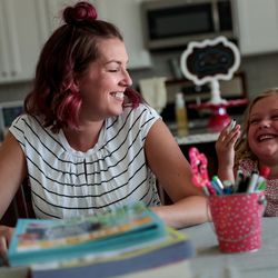 Amy Watts laughs with her daughter, Eve, 4, while she and Watts’ other daughters, Nora, 6, and Reese, 9, not pictured, do educational worksheets to prepare for the coming school year at their home in Lehi, Utah, on Saturday, Aug. 17, 2019.