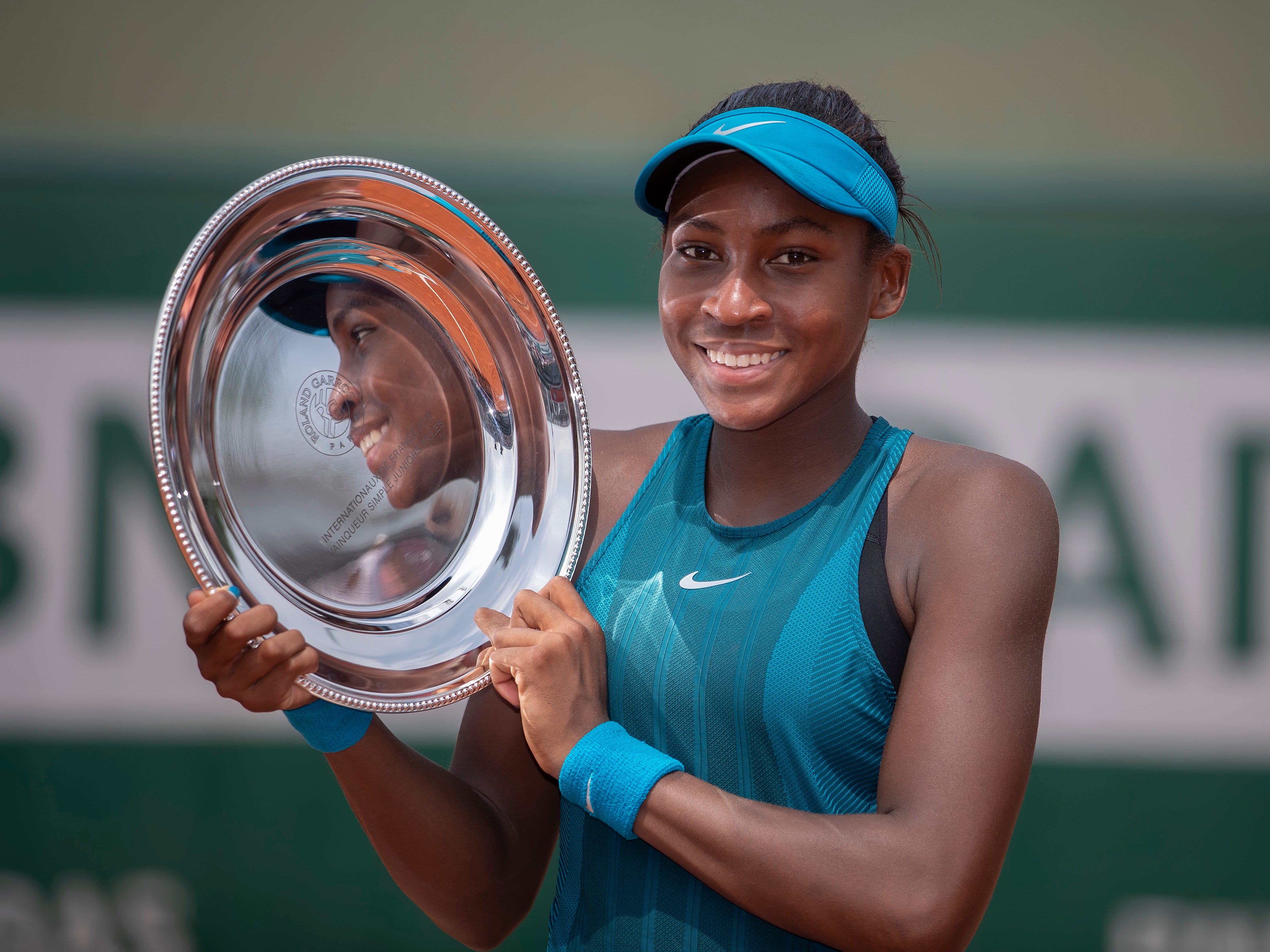 Coco Gauff poses with the trophy after winning her junior girls' final against Caty McNally at the 2018 French Open.