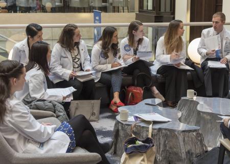 Medical students sitting in a circle taking notes