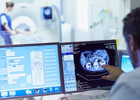 A physician viewing a patient's results on two computer screens