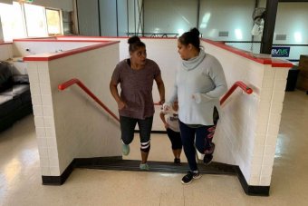 Moorundie Ruwe Ninkawi members participate in stair run Two women are running up the stairs looking at each other. They are wearing sporty clothes.