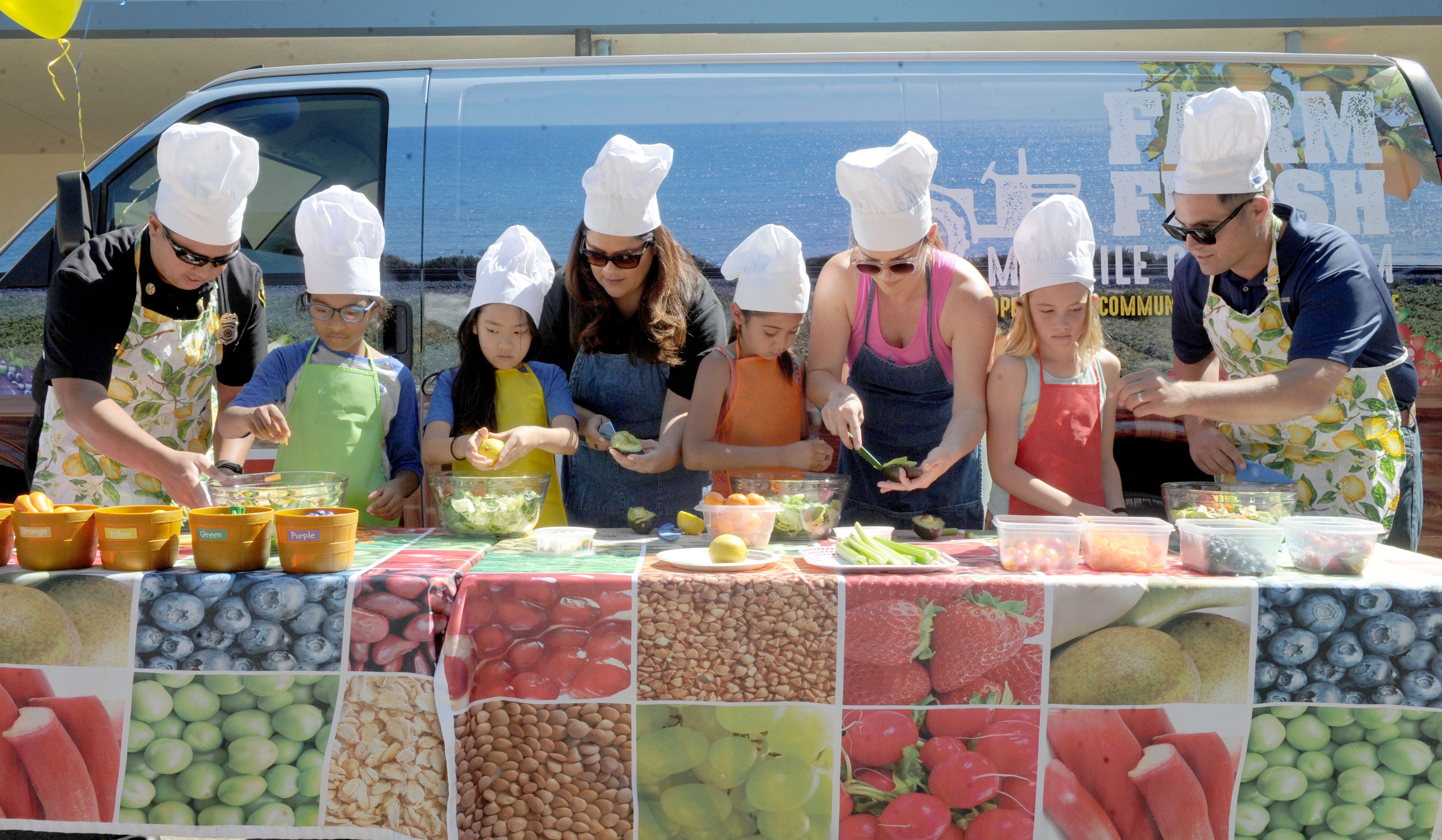 Adult volunteers and third-graders compete in a salad-making contest as Students for Eco-Education and Agriculture’s 30-foot Farm Fresh van came to Mound Elementary in Ventura.
