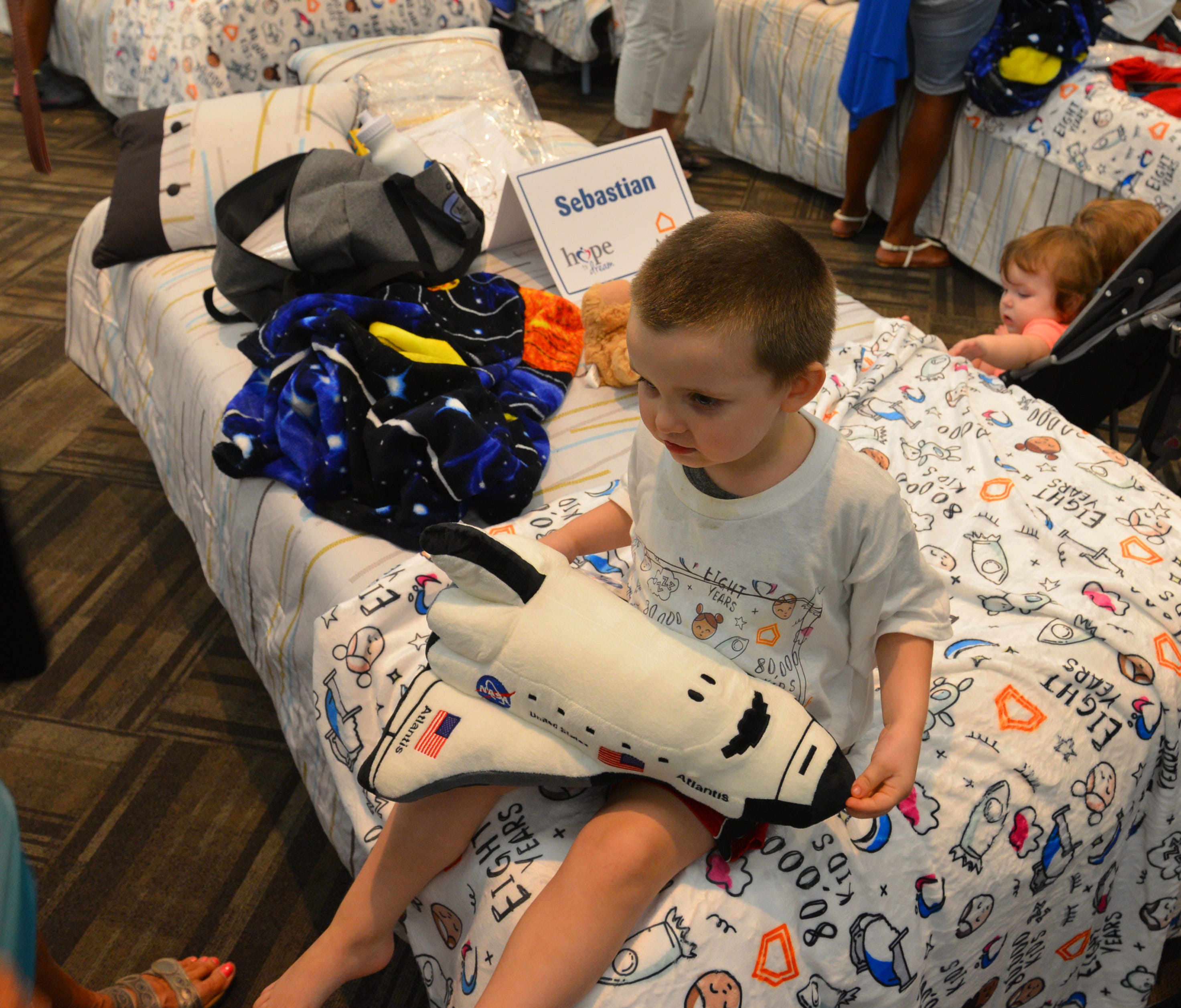 50 students from four Brevard schools were invited to Kennedy Space Center Visitor Complex Friday afternoon for the Ashley HomeStoreâ€™s national â€œHope to Dreamâ€ program to surprise 50 children an afternoon at the Kennedy Space Center Visitor Complex, followed by a mass bed reveal, where kids will receive their very own bed. Children will receive a twin mattress, bed frame, pillow, comforter, mattress protector, swag bag and teddy bear. These children do not have their own bed, they either share with their parent or siblings, sleep on the sofa or on the floor. Ashley's HomeStore Hope to Dream program has given out 90,000 beds since 2010. 