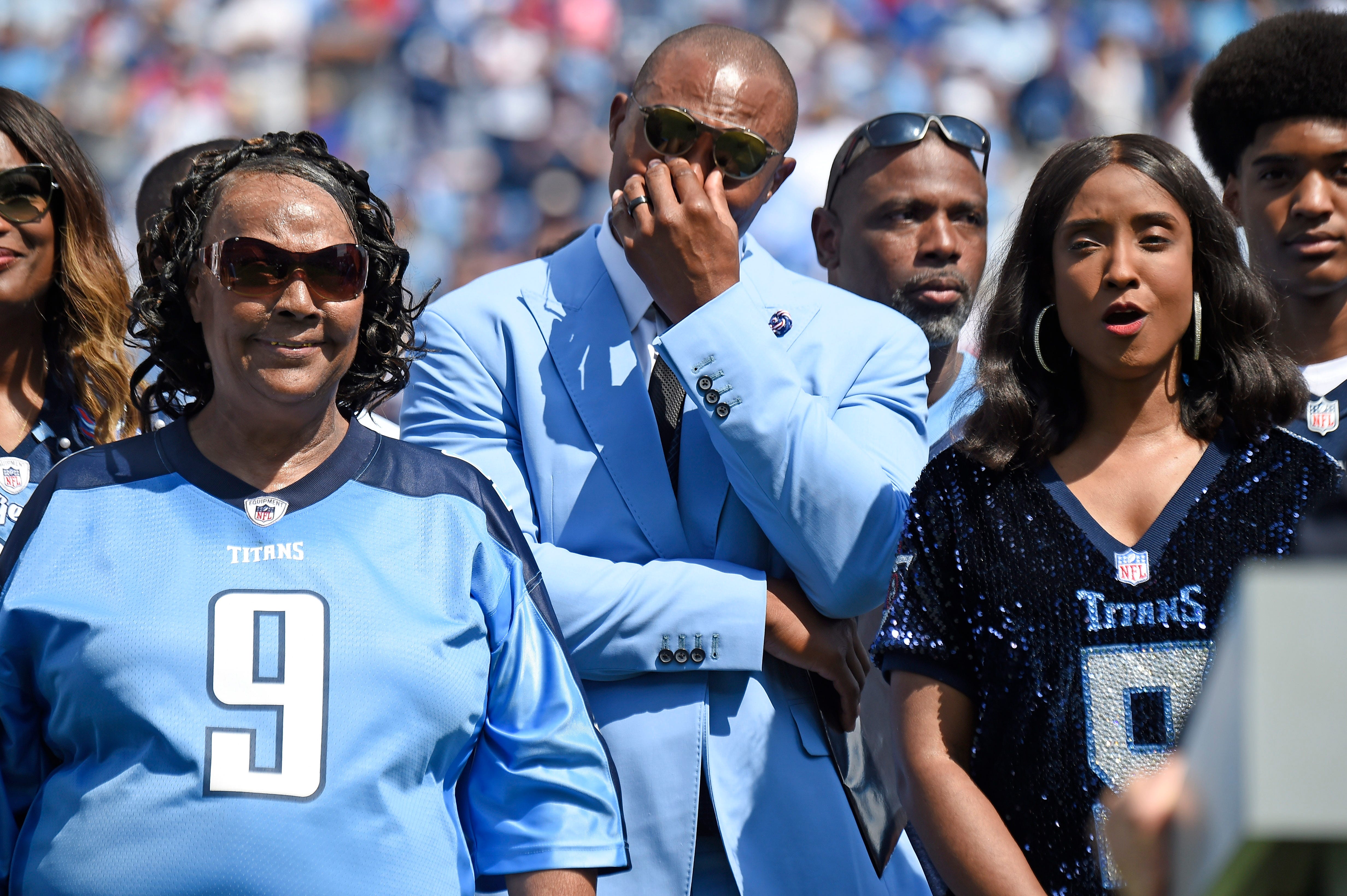 Former Titans great Eddie George gets emotional surrounded by Lucille McNair and Mechelle McNair, mother and widow of the late Steve McNair, as their jersey numbers are retired during halftime at Nissan Stadium Sunday, Sept. 15, 2019 in Nashville, Tenn. 