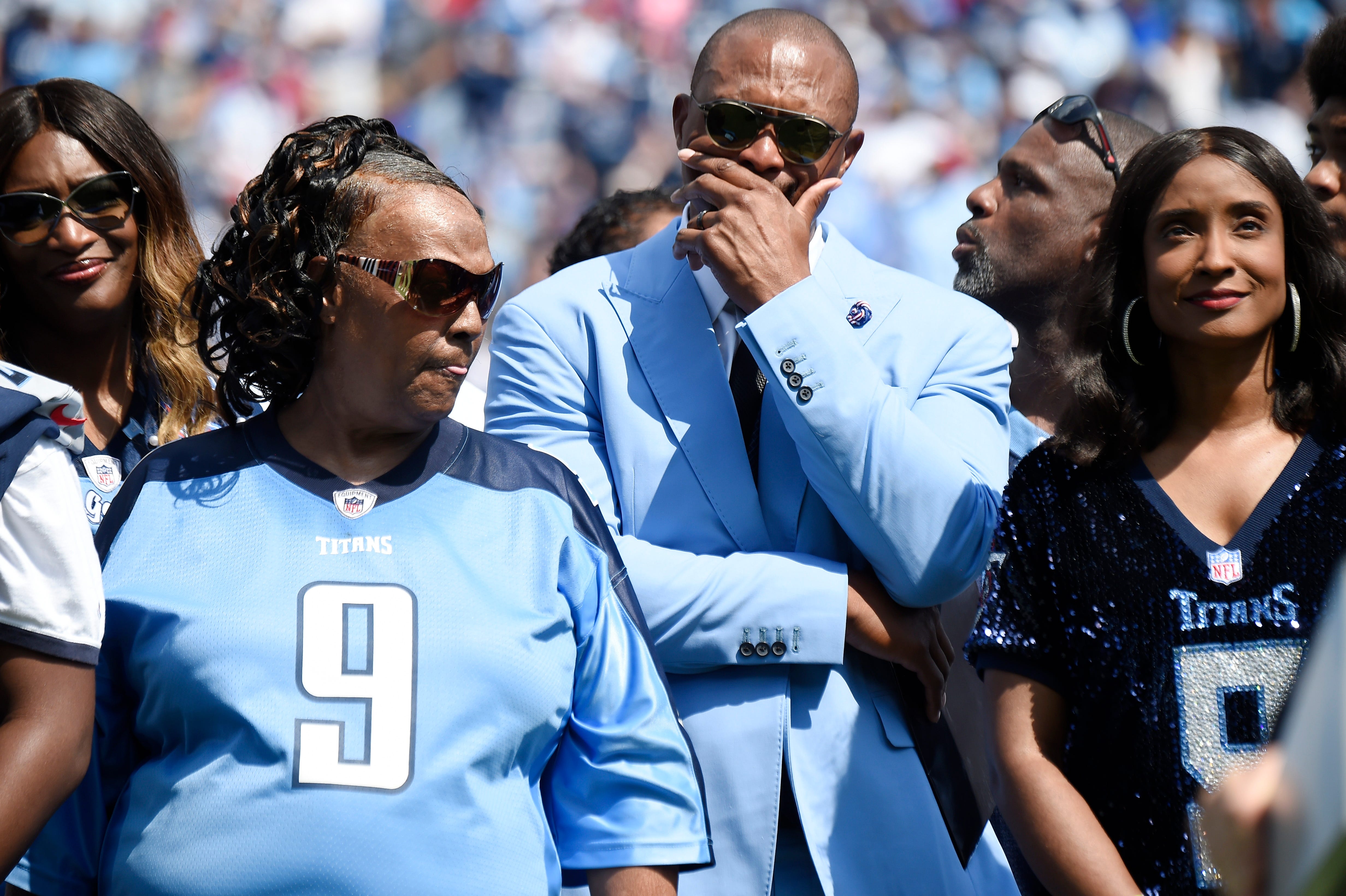 Former Titans great Eddie George gets emotional surrounded by Lucille McNair and Mechelle McNair, mother and widow of the late Steve McNair, as their jersey numbers are retired during halftime at Nissan Stadium Sunday, Sept. 15, 2019 in Nashville, Tenn. 