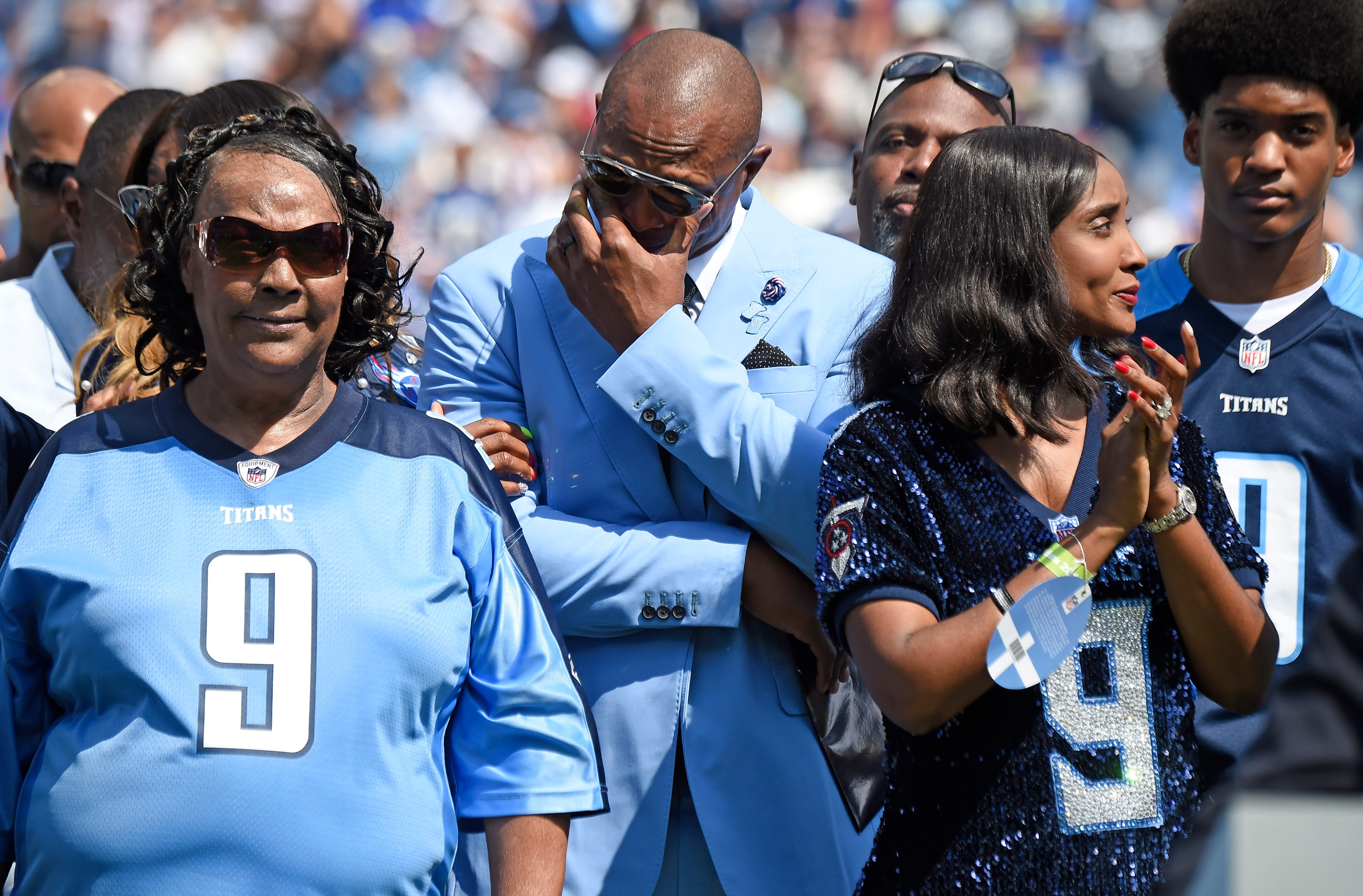 Former Titans great Eddie George gets emotional surrounded by Lucille McNair and Mechelle McNair, mother and widow of the late Steve McNair, as their jersey numbers are retired during halftime at Nissan Stadium Sunday, Sept. 15, 2019 in Nashville, Tenn. 