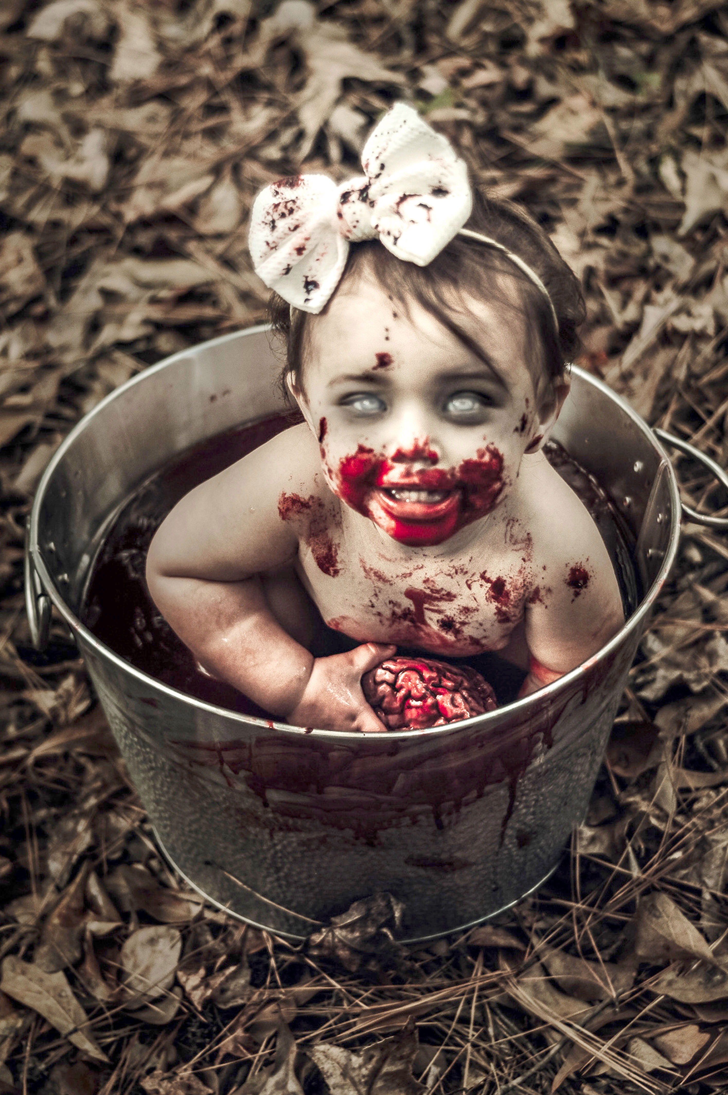  Buckets of blood: Coraline, 12 months old, grins cheekily at her mum in the Halloween photoshoot