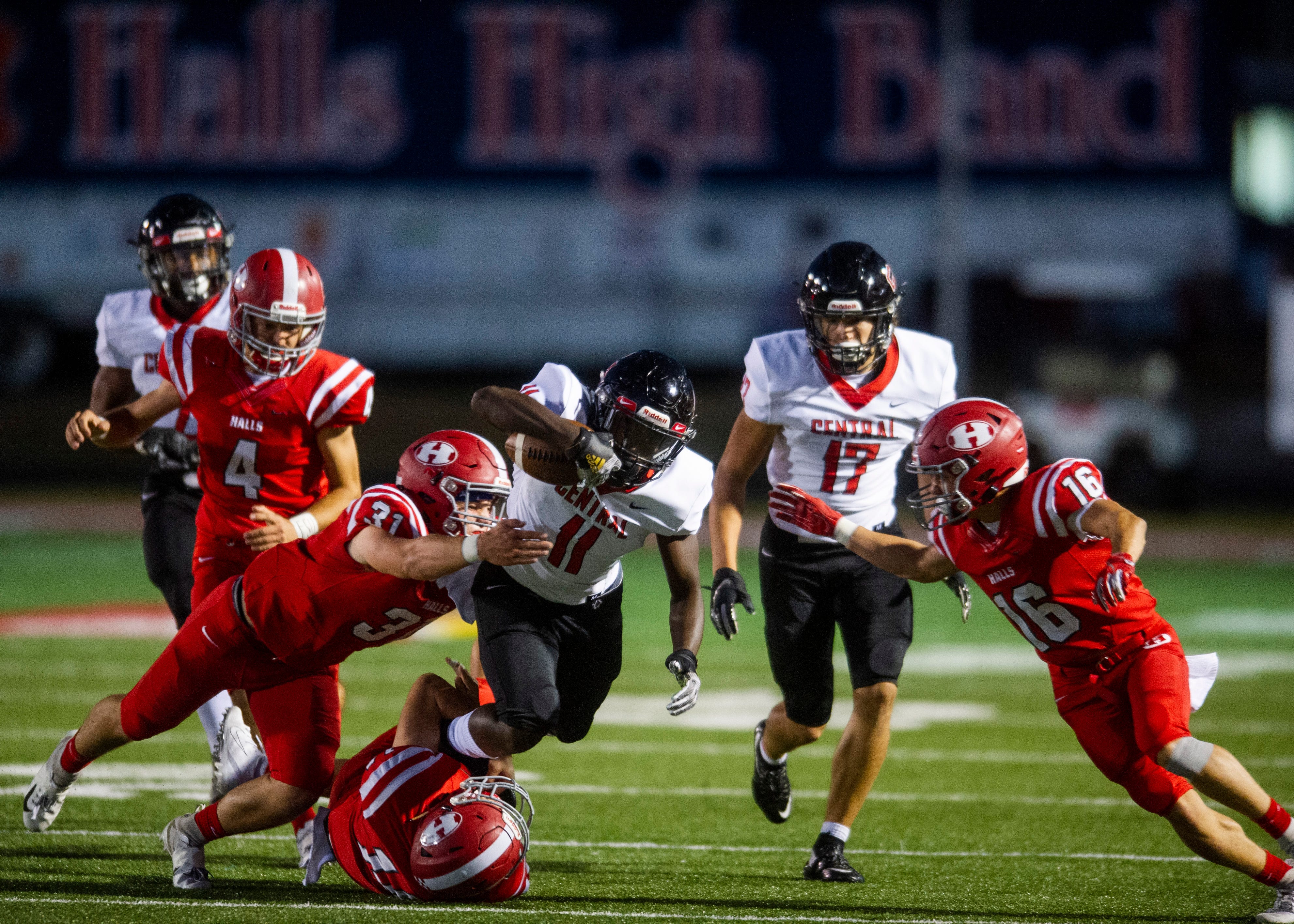 Central's Jason Merritts (11) is tackled by Halls' Brett McMahan (31) and Jackson Cates (14) during the Halls and Central high school football game on Friday, October 4, 2019 at Halls High School.