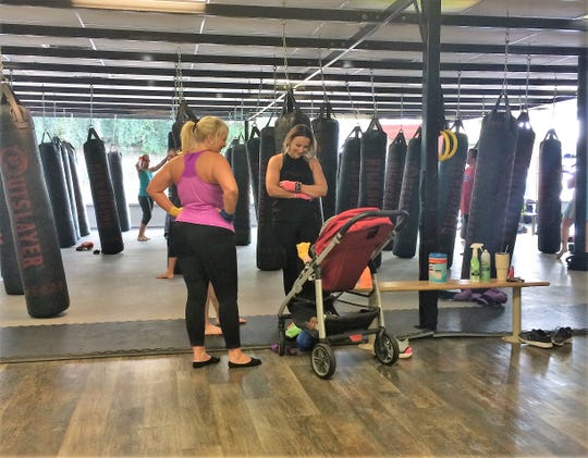 One of the benefits of a workout at Total Fitness Kickboxing for Kara Capalbo, right, of Powell is to spend some time enjoying 6-month-old Landyn Chandler.