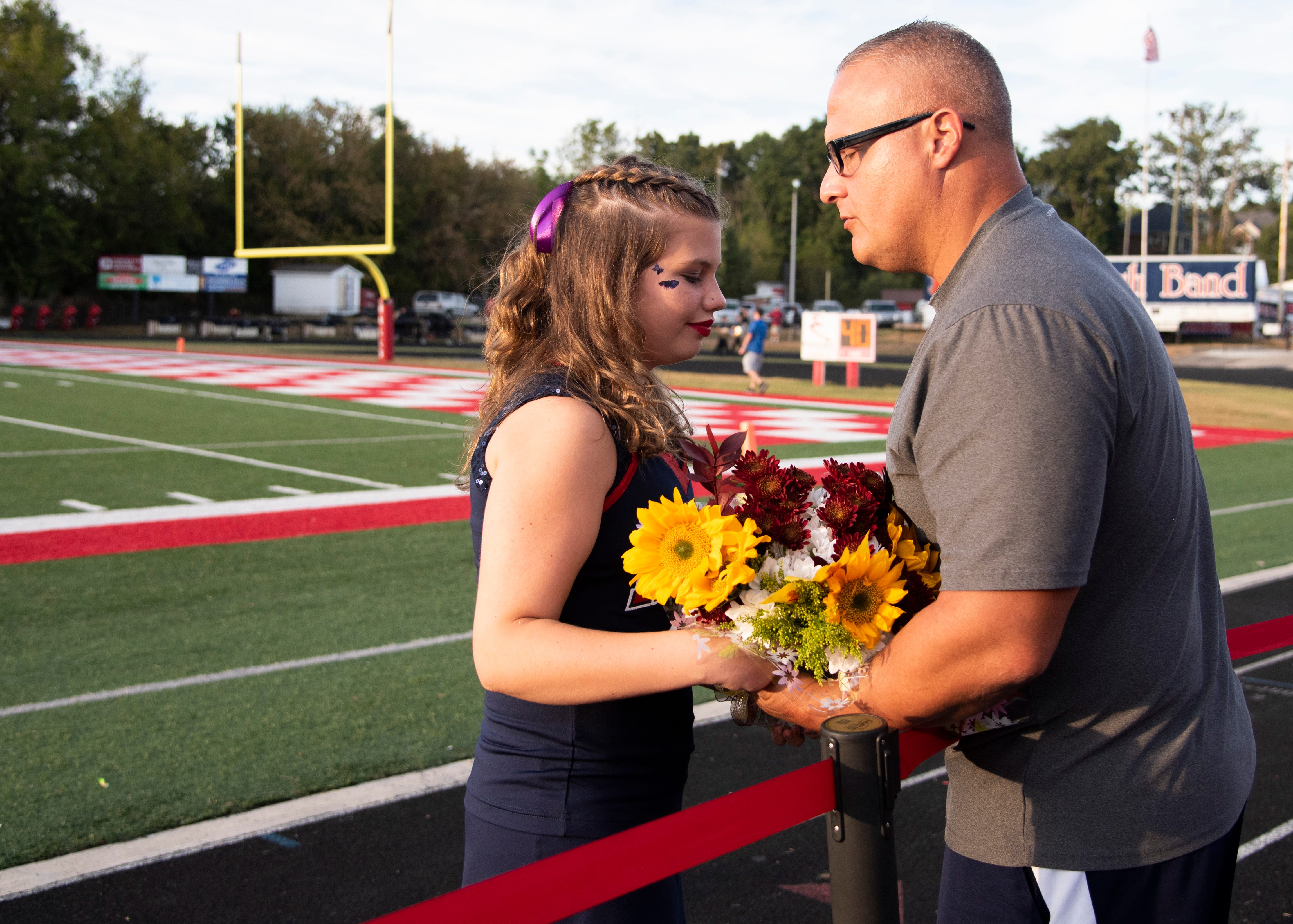 Eric Brefini hands his daughter and Halls junior, Cheyenne flowers before the Halls and Central high school football game on Friday, October 4, 2019 at Halls High School. He said, "I think every girl should be homecoming queen."