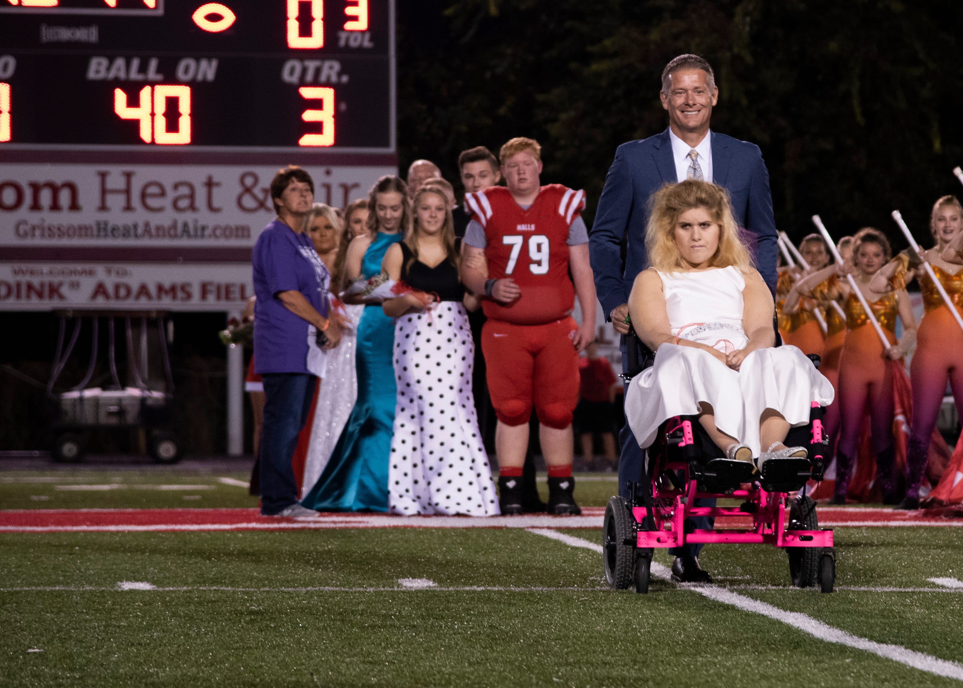 Halls homecoming court member, Blakeley Irwin, is escorted to the field during the Halls and Central high school football game on Friday, October 4, 2019 at Halls High School.