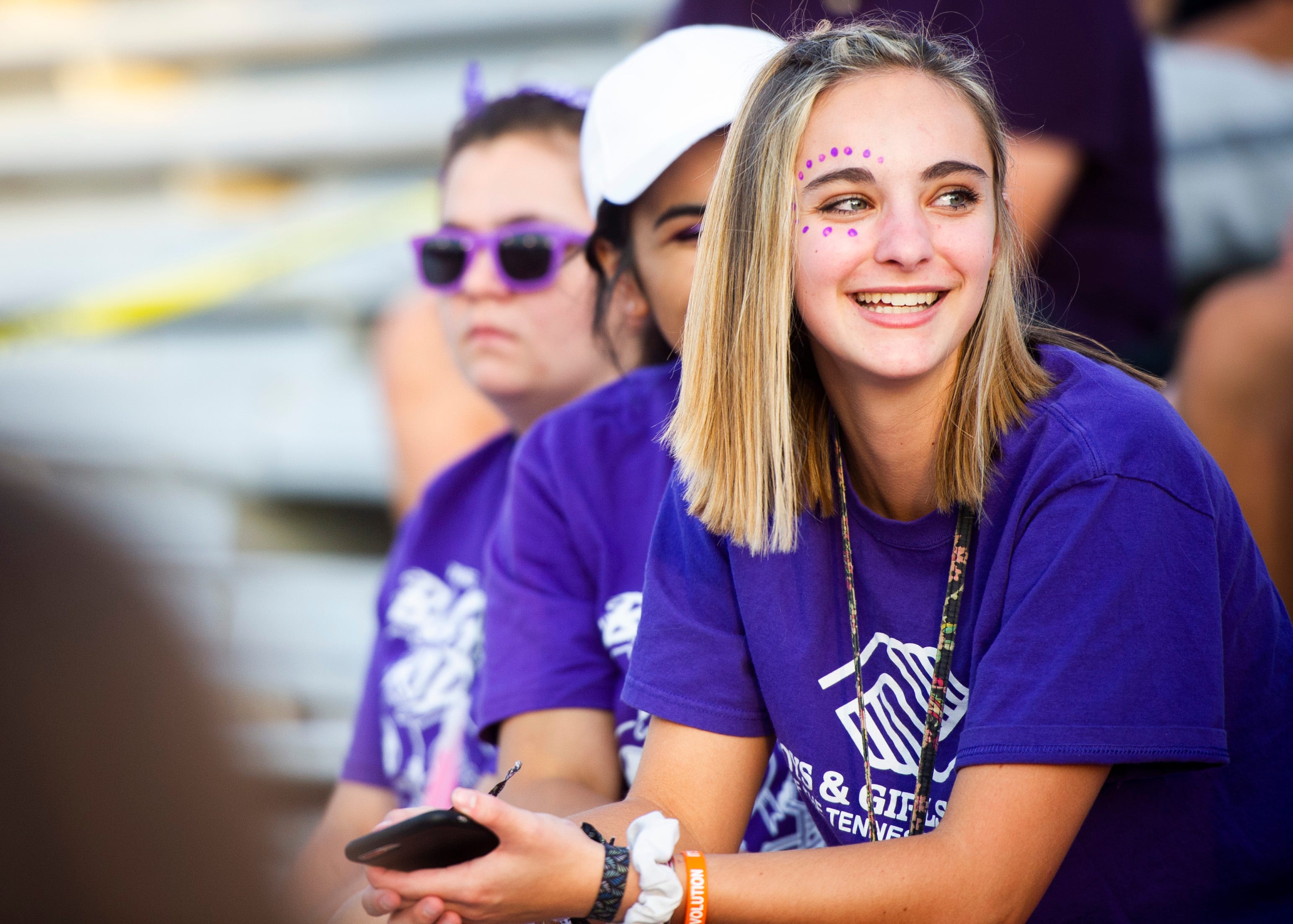 Dressed for the "Purple Out," senior, Bailee Hatmaker, sits in the student section before the Halls and Central high school football game on Friday, October 4, 2019 at Halls High School.