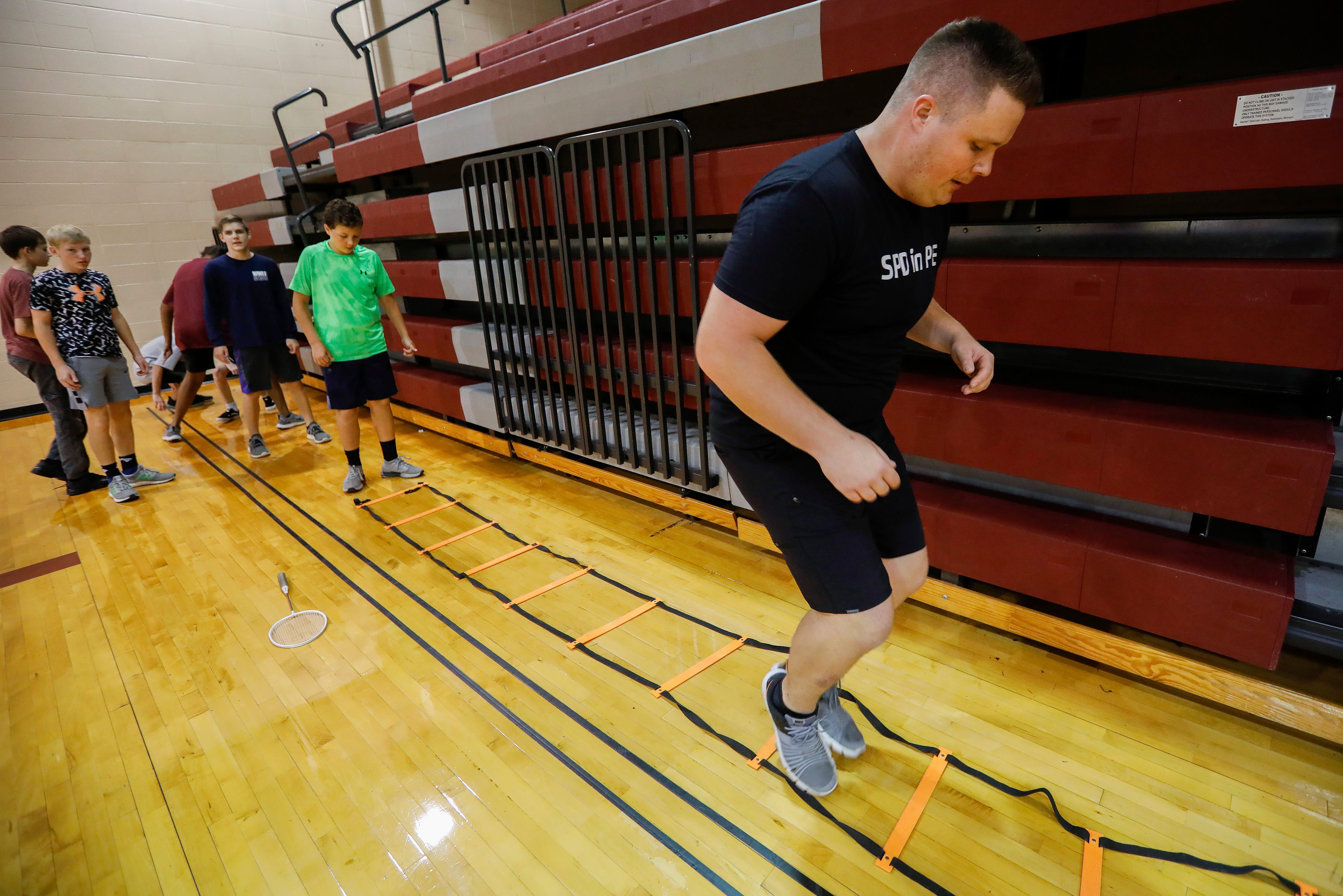 Springfield Police Officer Keith Wright runs through the ladder exercise with seventh-graders at Cherokee Middle School as part of the SPD in PE program on Wednesday.