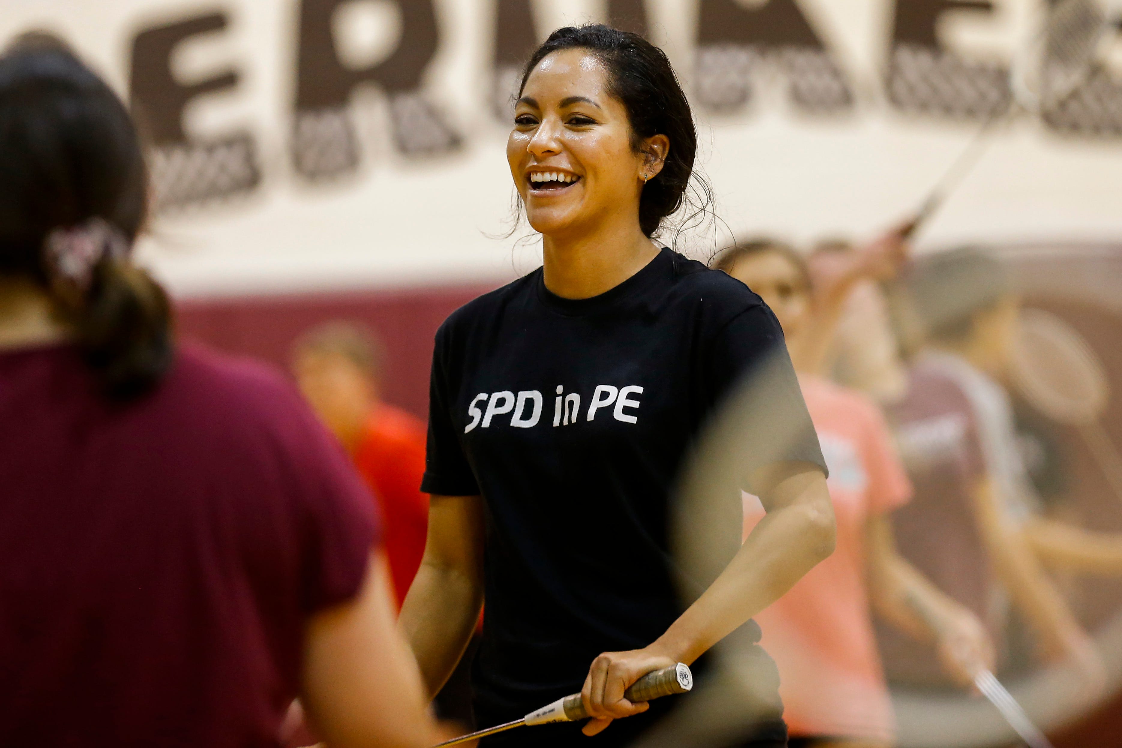 Springfield Police Department Public Information Officer Jasmine Bailey laughs as she plays badminton with seventh-graders at Cherokee Middle School as part of the SPD in PE program on Wednesday.