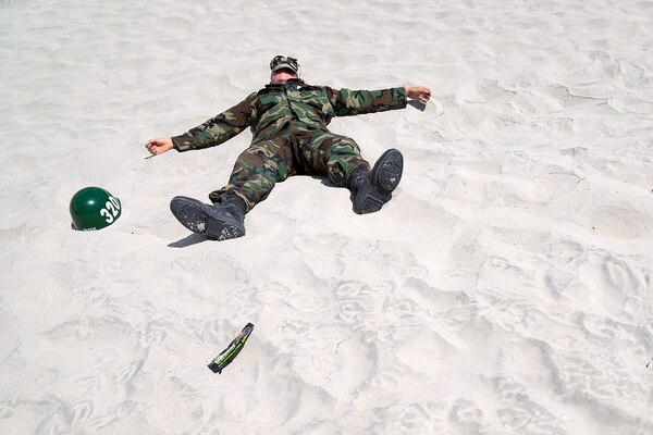 A sailor participating in First Phase Basic Underwater Demolition/SEAL (BUD/S) training recovers during a lunch break in 2016. He had just survived 