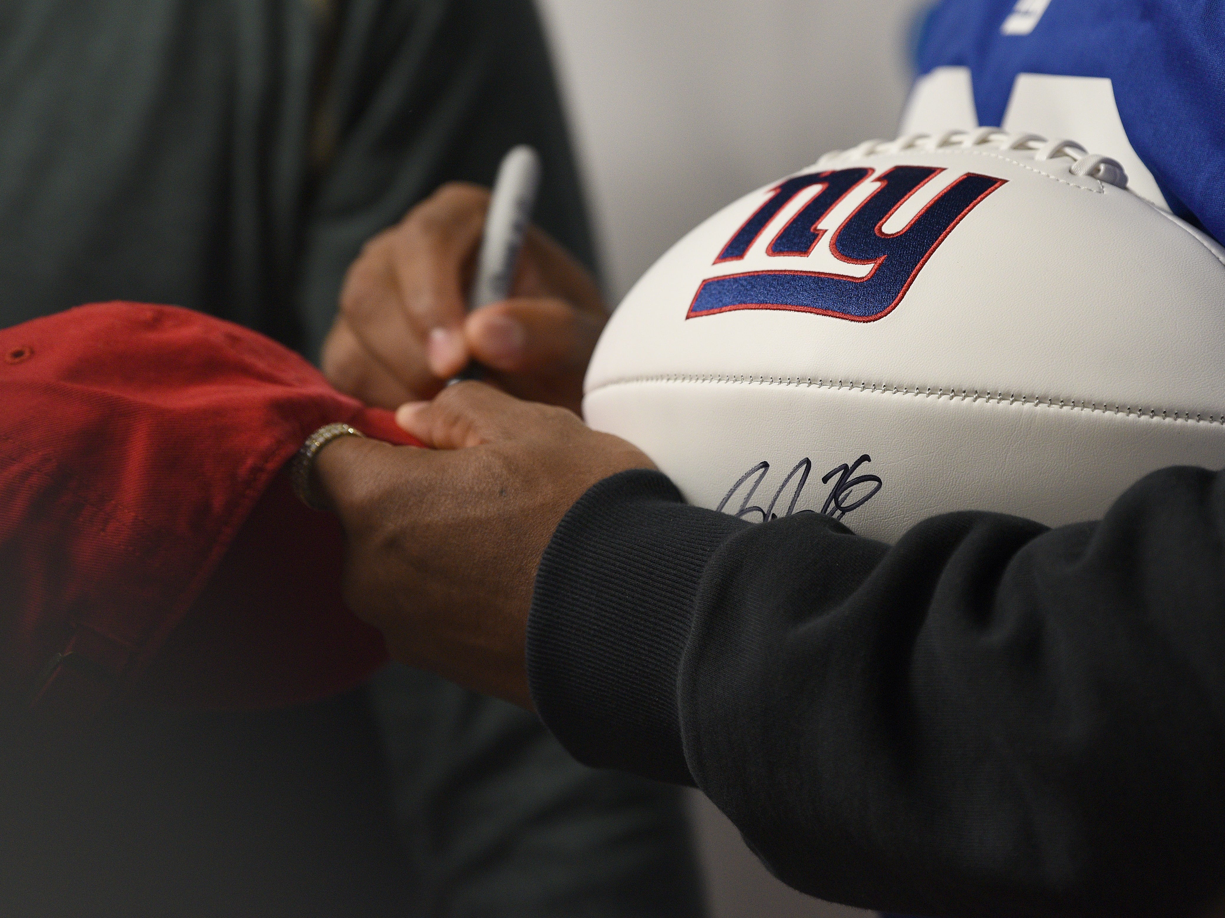 Covenant House holds a Sleep Out Executive Edition in Newark on Thursday November 21, 2019. Saquon Barkley a player with the Giants and Sleep Out: Executive Edition Chairman, signs a hat. 