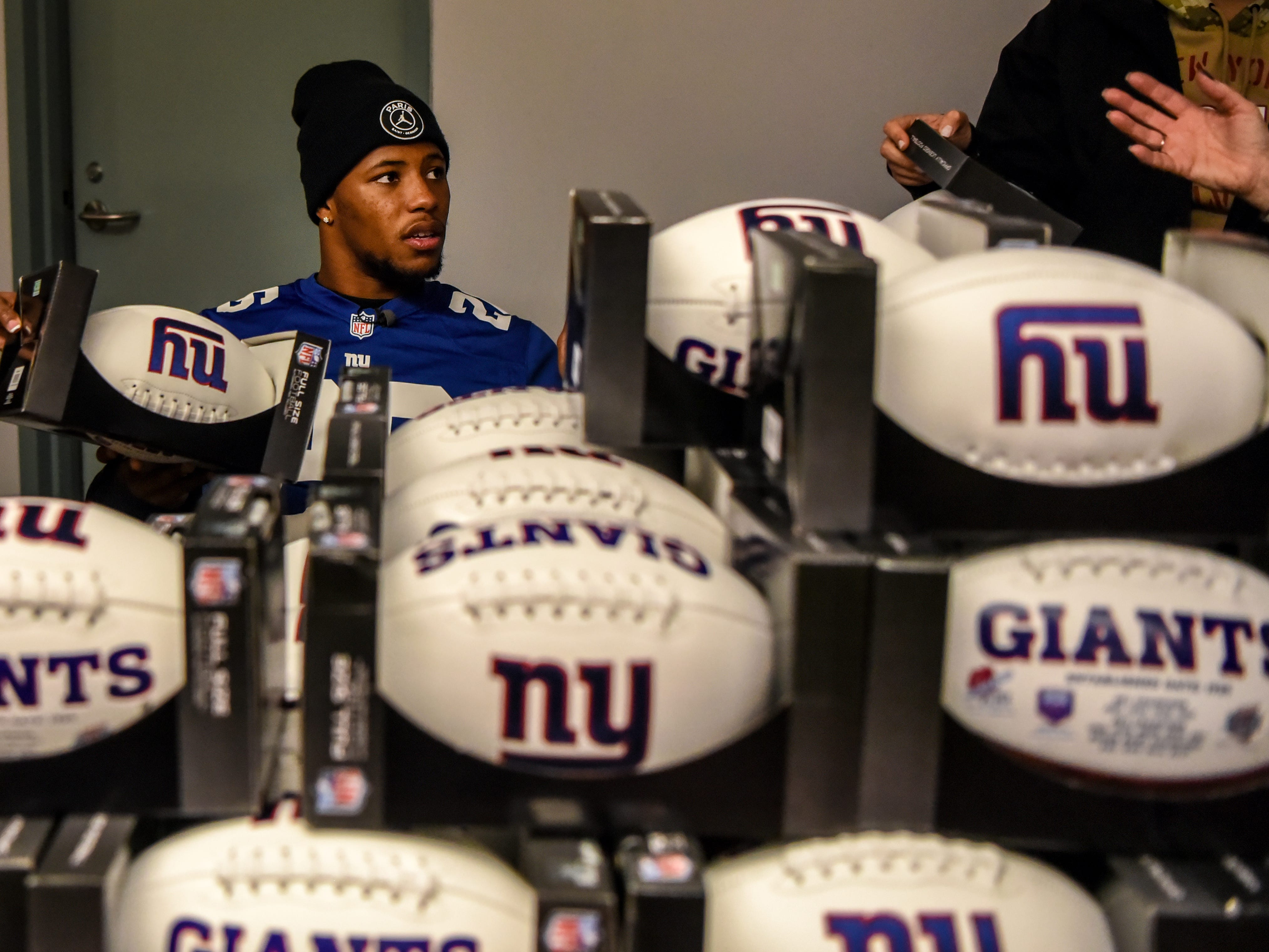 Covenant House holds a Sleep Out Executive Edition in Newark on Thursday November 21, 2019. Saquon Barkley from the Giants and Sleep Out: Executive Edition Chairman, sits behind a wall of Giants branded footballs that he signs for people at the Sleep Out. 