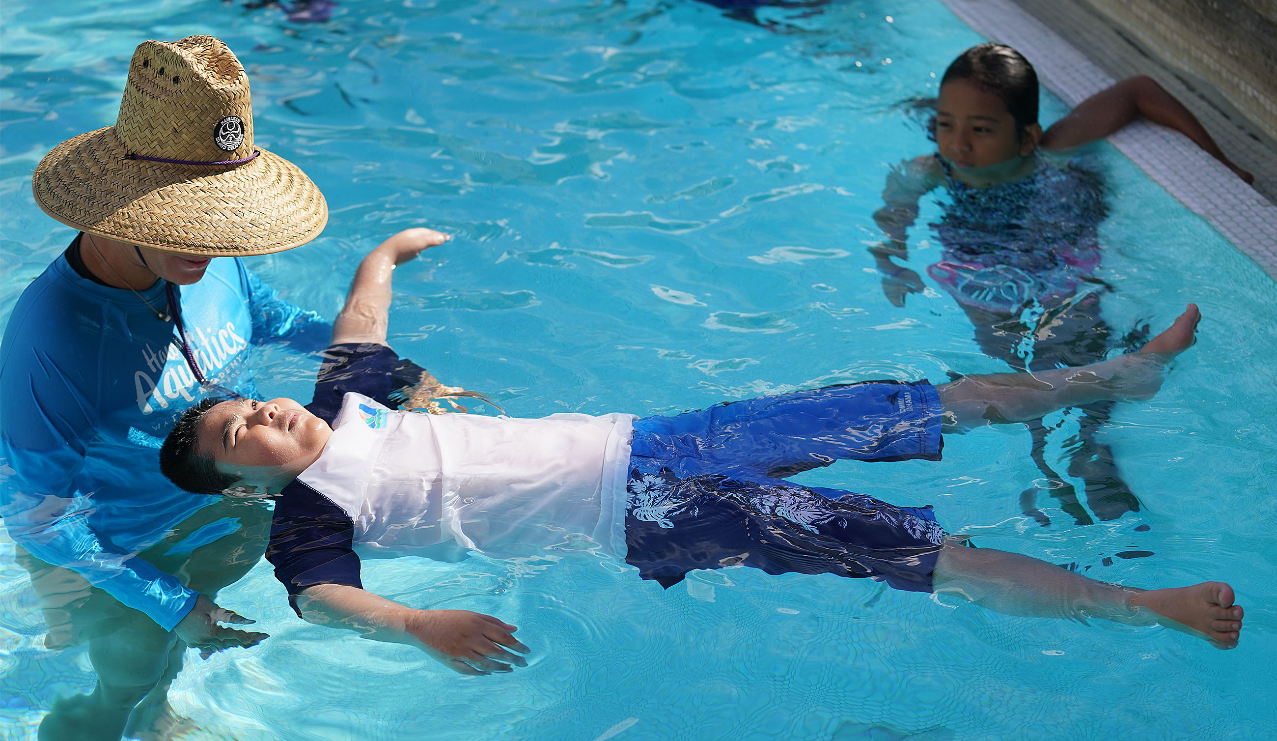 Palama Settlement pool swimming class as student learn how to float on their backs during class.
