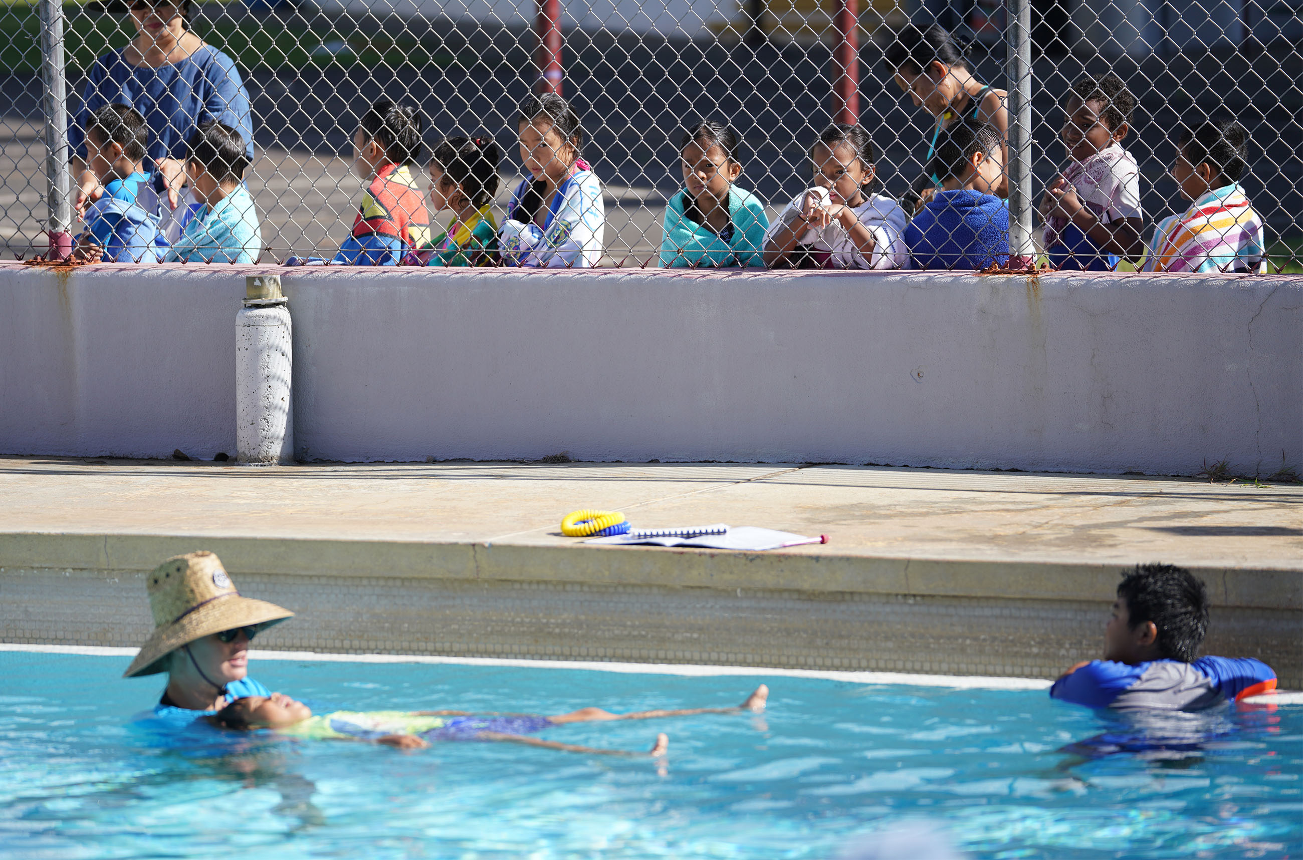 Lanakila Elementary second graders watch eagerly, the swimming class after theirs. So much enthusiasm and thirst for learning swimming at the Palama Settlement swimming pool.
