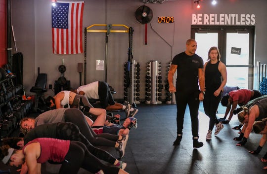 Brian Daniels and Leah Traciak-Zenker, owners of EmPOWer gym on East Michigan Avenue, in Lansing work with participants in their class on Saturday, Nov. 23, 2019.