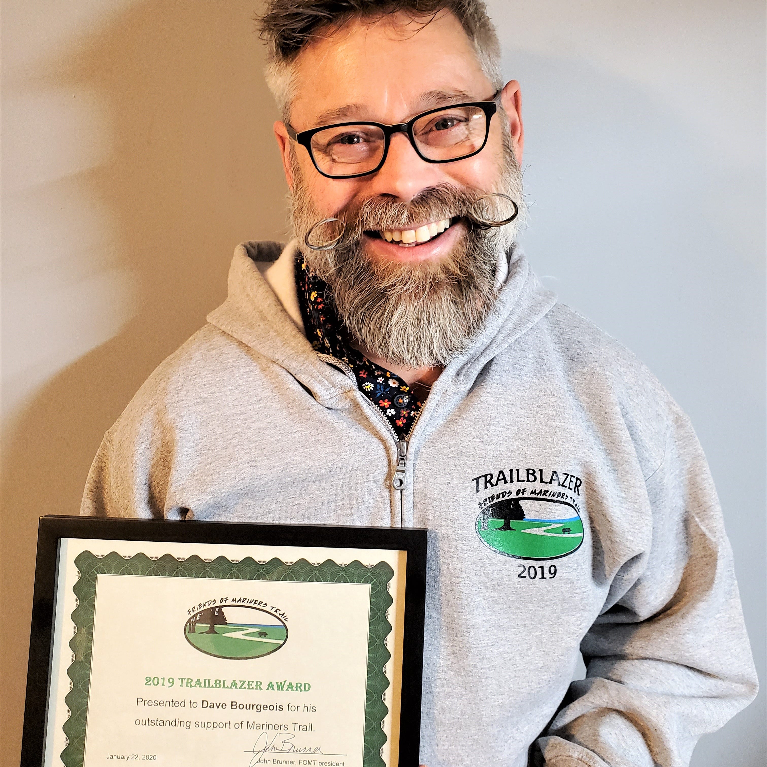 Dave Bourgeois wearing his Trail Blazer shirt and holding the certificate honoring him as the Friends of Mariners Trail's 13th annual Trail Blazer winner.