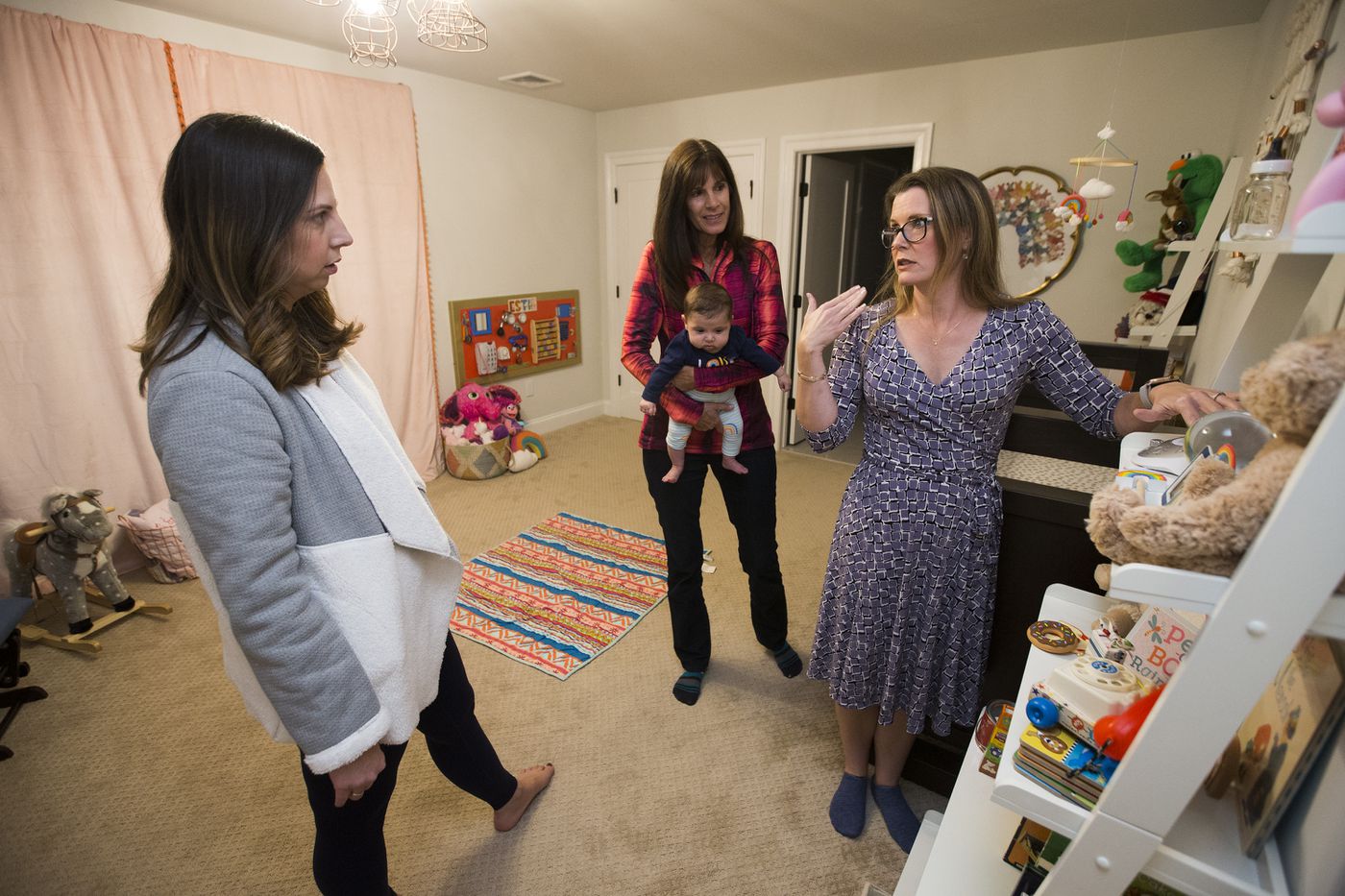 Jennifer Schindele (right) goes over the bedtime routine with mother Debbie Parnes (left) and nanny Annette Zeglen, holding Debbie’s daughter, Estie Herman.