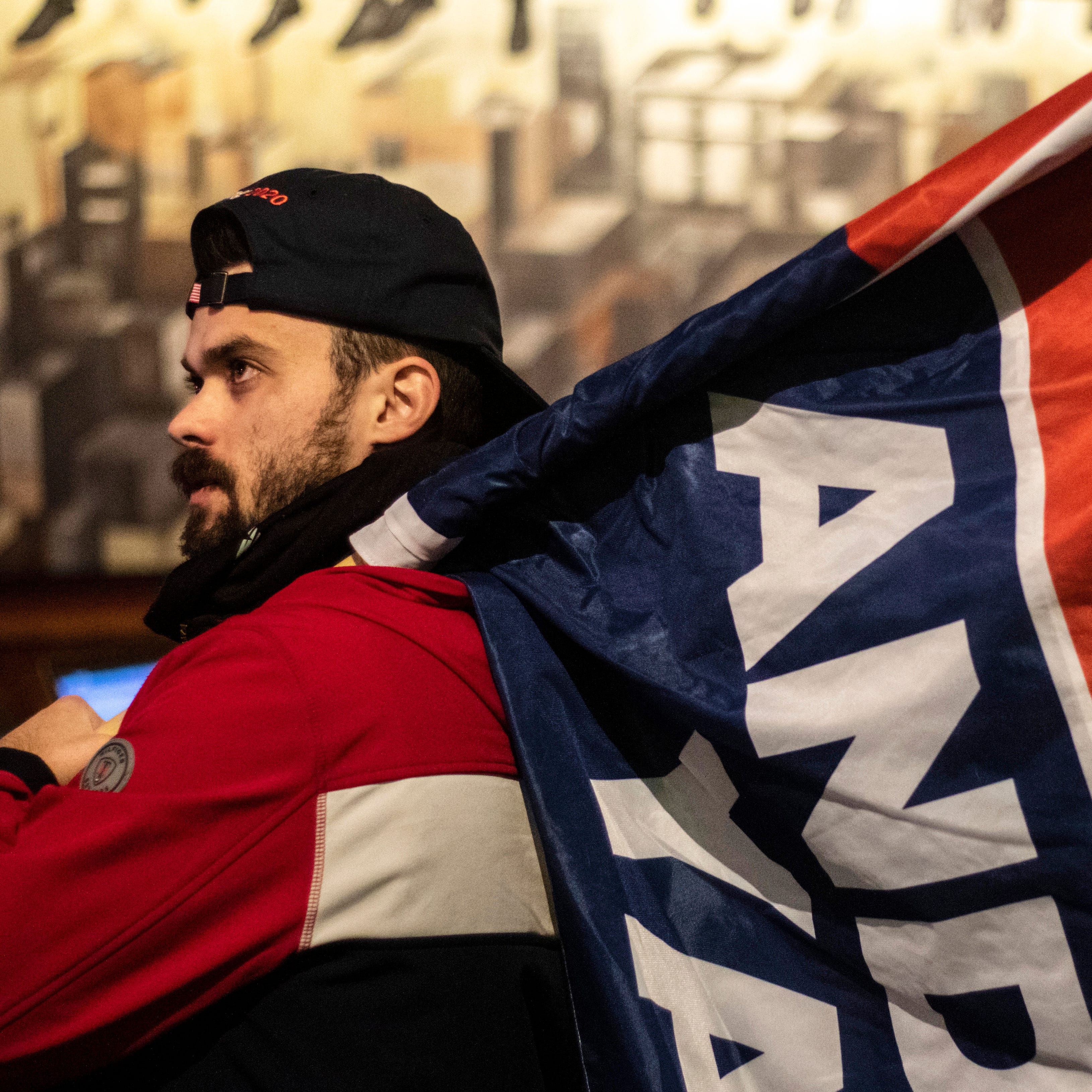 Tully Baker, of New Hampshire, carries a flag in support of Democratic presidential candidate Andrew Yang during a watch party for the CNN/Des Moines Register Democratic Presidential Debate, Tuesday, Jan. 14, 2020, at Papa Keno's Pizzeria in Des Moines, Iowa.