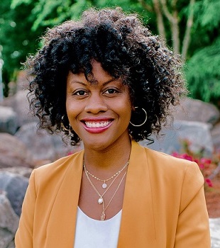 self-care: Ashley Witherspoon (headshot), licensed clinical social worker, smiling woman with dark curly hair, earrings, necklaces wearing apricot pantsuit and white top