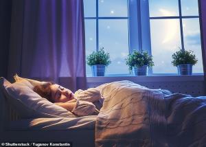 a person sitting on a bed next to a window: Dr Nerina Ramlakhan, a physiologist, sleep therapist and resident expert with UK brand Silentnight, explained that some children will be struggling to adjust to going back to school after months at home. Stock image