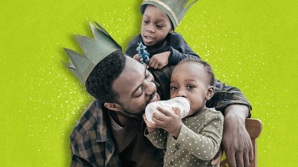 Adult man with 2 kids playing while one drinks a bottle of toddler formula.